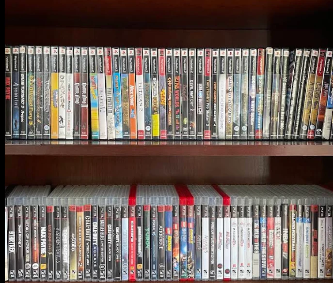 Two full shelves of PlayStation 2 and PlayStation 3 games in cases